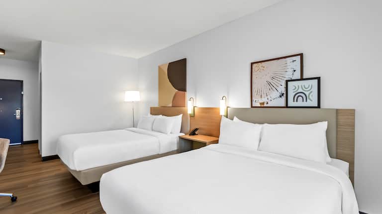 Guest room with two queen beds and modern wall art